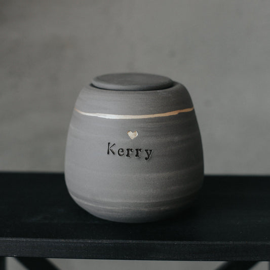 Handcrafted gray stoneware dog urn with gold heart stamp - personalized with dog's name.