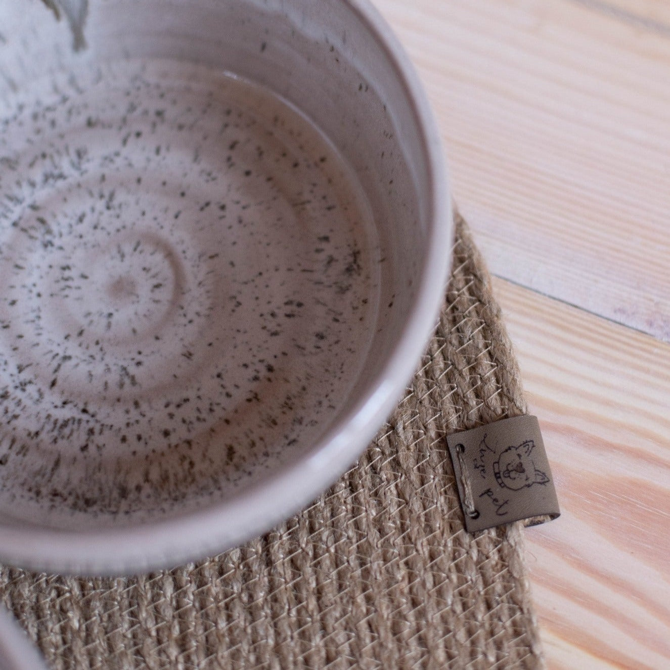 Two chic gray ceramic dog bowls with a matching jute mat. A stylish upgrade for your pet's feeding area.