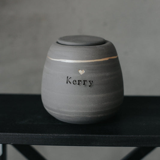 Handcrafted gray stoneware dog urn with gold heart stamp - personalized with dog's name.