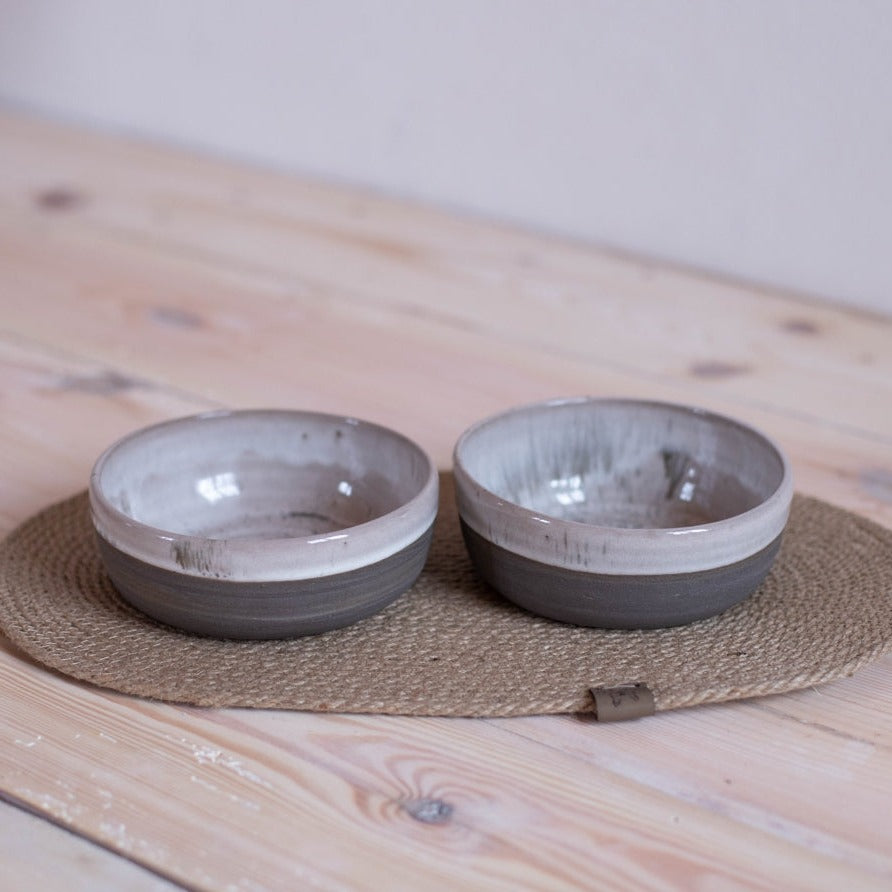 Pamper your pup with this handcrafted ceramic dog bowl set. Includes 2 bowls and a feeding mat.