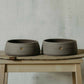 Two handmade gray stoneware dog bowls with paw stamp - perfect for modern pet dining.