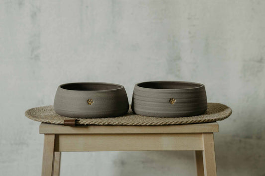 Two handmade gray stoneware dog bowls with paw stamp - perfect for modern pet dining.